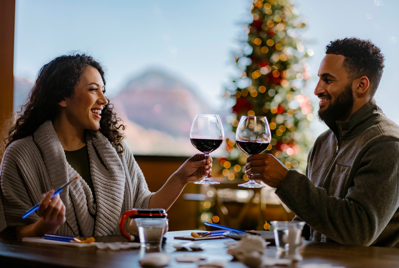 2 people experiencing the holiday art class with wine