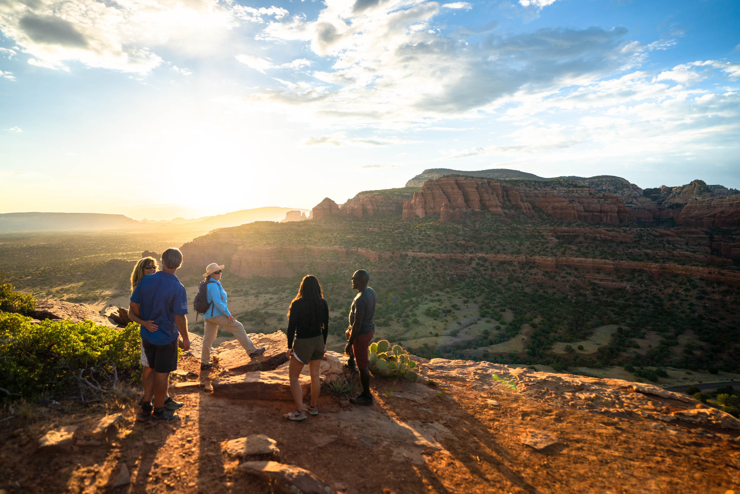 sunset hike with guide and hikers looking out as the sun dips into the horizon