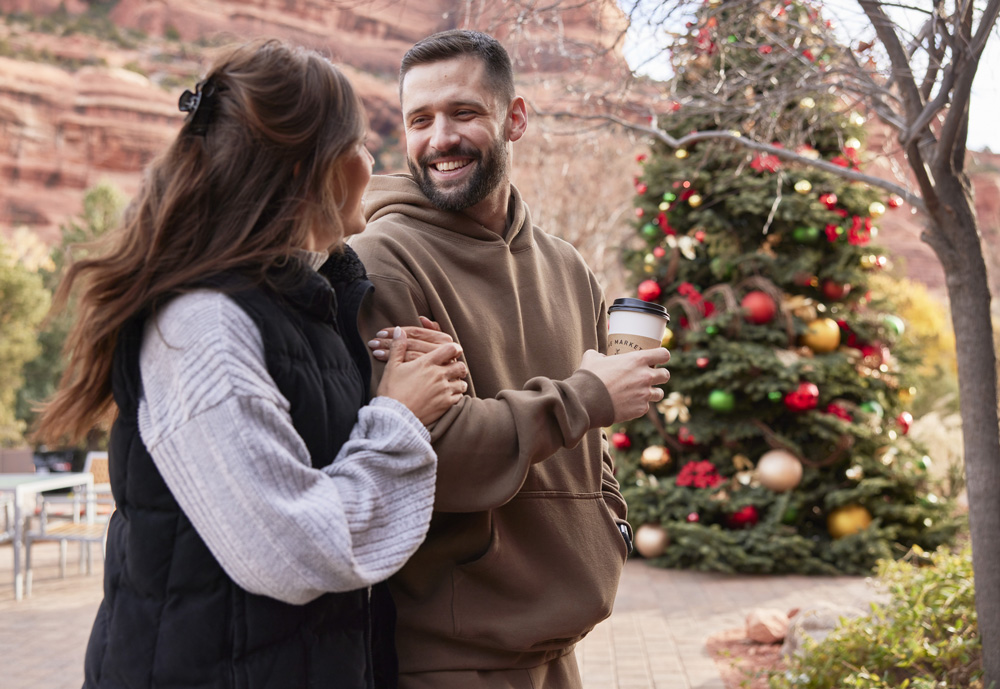 couple walking with coffees outside The Market at Enchantment Resort during Red Rock Holidays