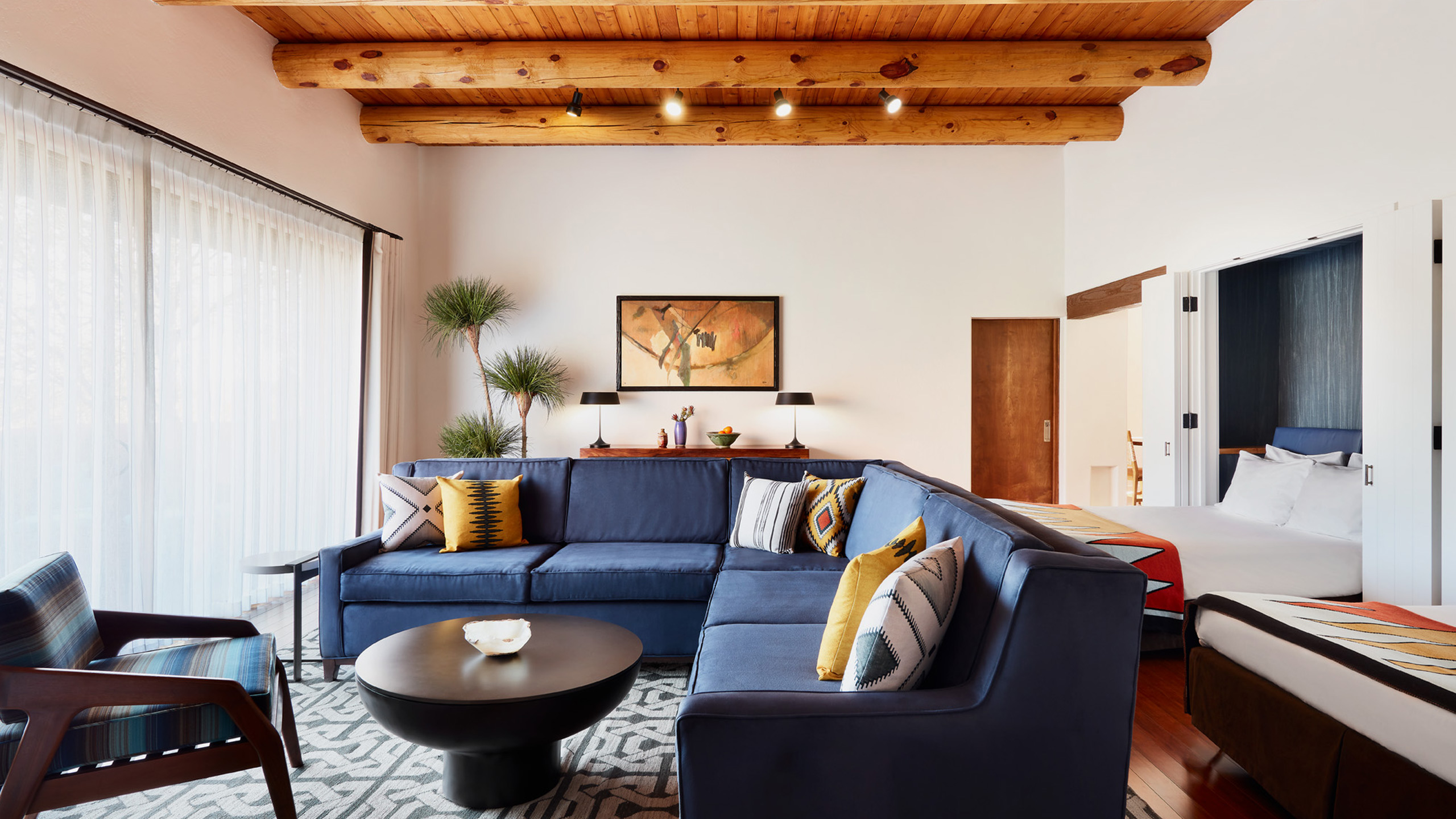 Hacienda 1 bedroom living room with blue couch and wood beam ceilings