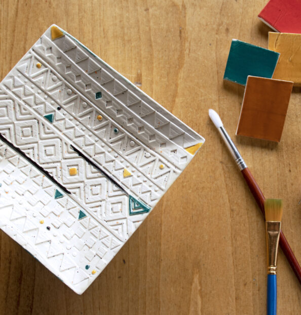 square plate with painted patterns and paintbrush